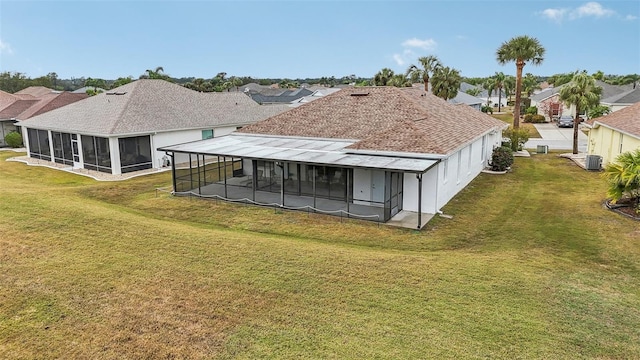 back of property featuring a sunroom and a yard