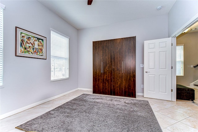 unfurnished bedroom featuring light tile patterned flooring and ceiling fan