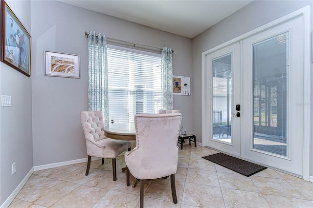 dining space with light tile patterned floors and french doors