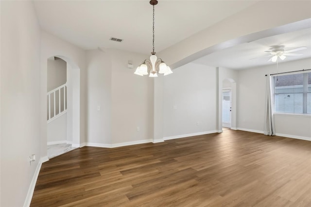 unfurnished room with ceiling fan with notable chandelier and dark hardwood / wood-style flooring