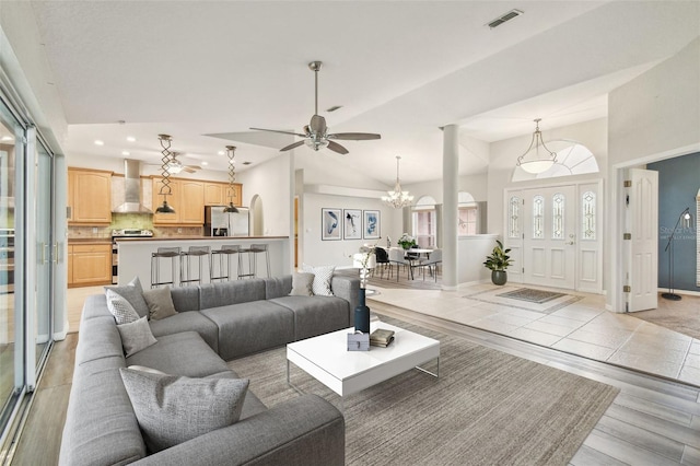 living room featuring ceiling fan with notable chandelier and high vaulted ceiling