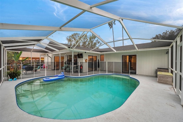 pool featuring glass enclosure and a patio area