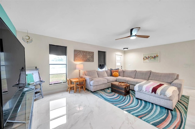 living room featuring marble finish floor, ceiling fan, and baseboards