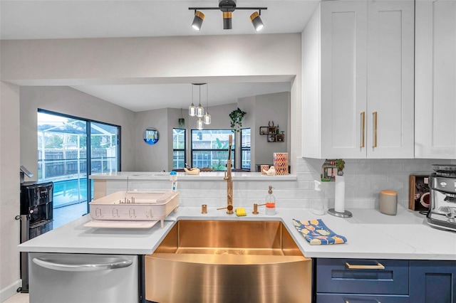 kitchen featuring blue cabinetry, sink, light stone counters, dishwasher, and decorative backsplash