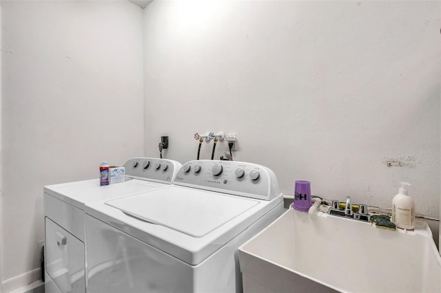 laundry room featuring laundry area, washing machine and dryer, and a sink