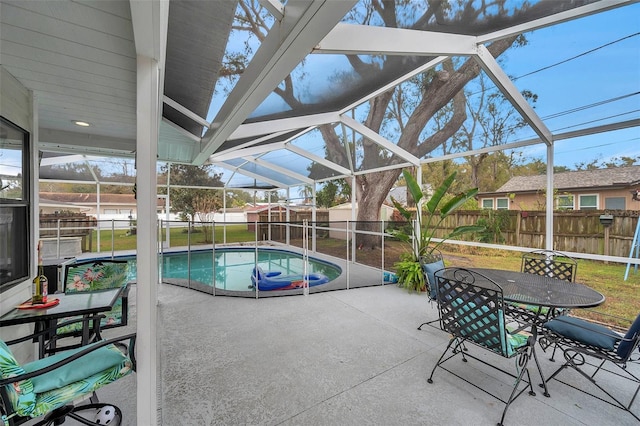 view of pool featuring a patio area, a lawn, and glass enclosure