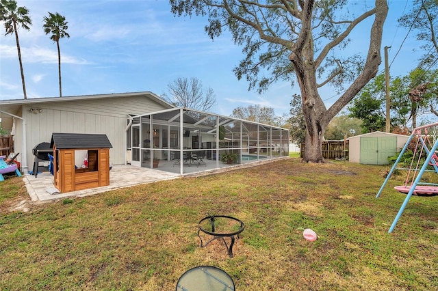 view of yard with a playground, a patio area, and a shed