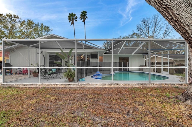 view of pool with a patio and glass enclosure