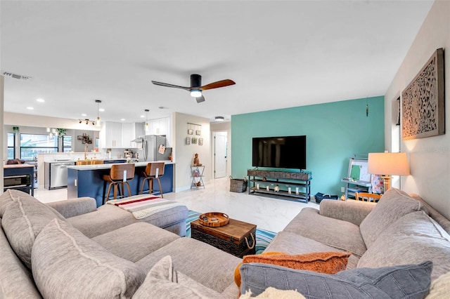 living room featuring a ceiling fan, recessed lighting, marble finish floor, and visible vents