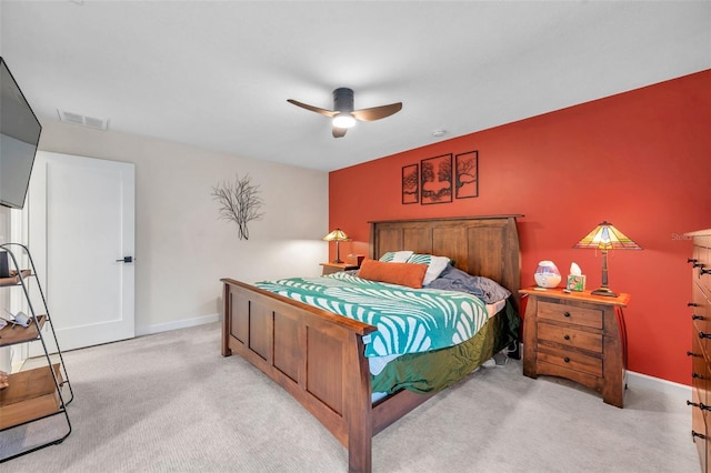 bedroom with baseboards, visible vents, a ceiling fan, and light colored carpet