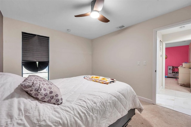 bedroom featuring a ceiling fan, light colored carpet, visible vents, and baseboards