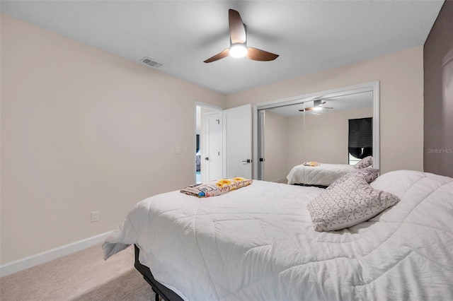 carpeted bedroom featuring a ceiling fan, a closet, visible vents, and baseboards