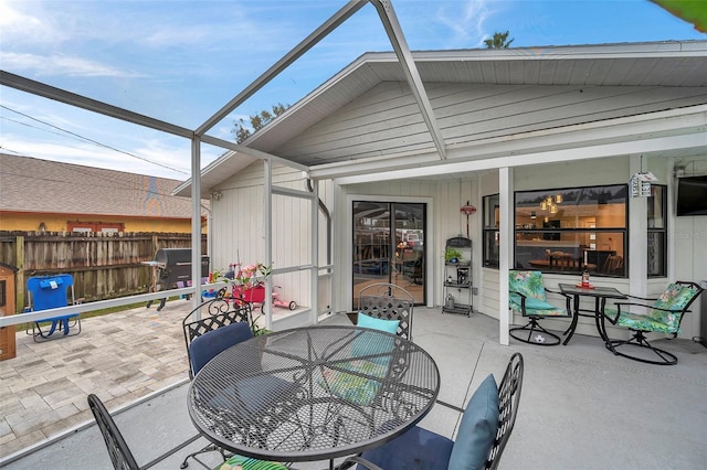 view of patio / terrace featuring outdoor dining area, fence, and a lanai