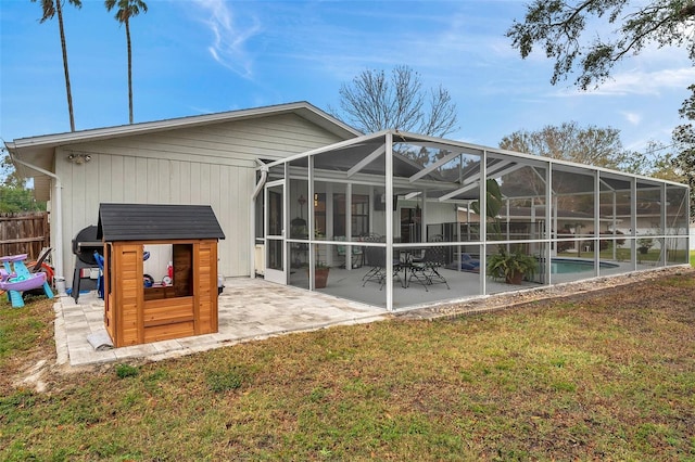 rear view of house featuring a patio, glass enclosure, fence, a lawn, and an outdoor pool