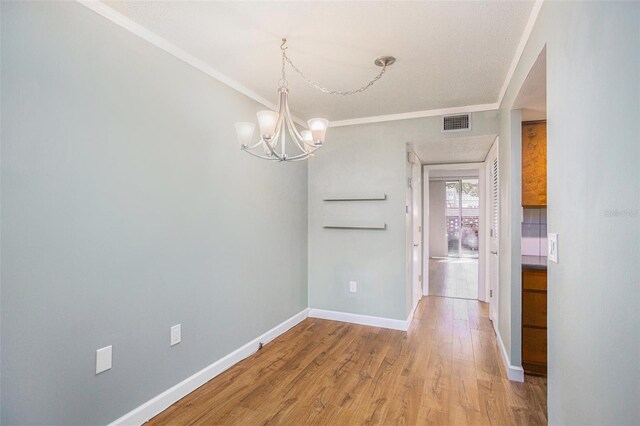 2635 Seville Blvd Unit 109, Clearwater, FL 33764 - unfurnished dining area with hardwood / wood-style flooring, ornamental molding, and an inviting chandelier