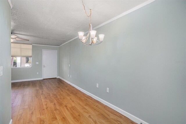 2635 Seville Blvd Unit 109, Clearwater, FL 33764 - empty room with wood-type flooring, ceiling fan with notable chandelier, a textured ceiling, and ornamental molding