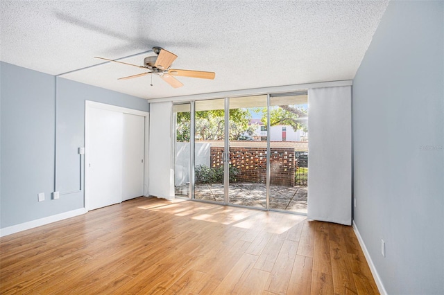 2635 Seville Blvd Unit 109, Clearwater, FL 33764 - unfurnished room with floor to ceiling windows, a textured ceiling, light hardwood / wood-style flooring, and ceiling fan