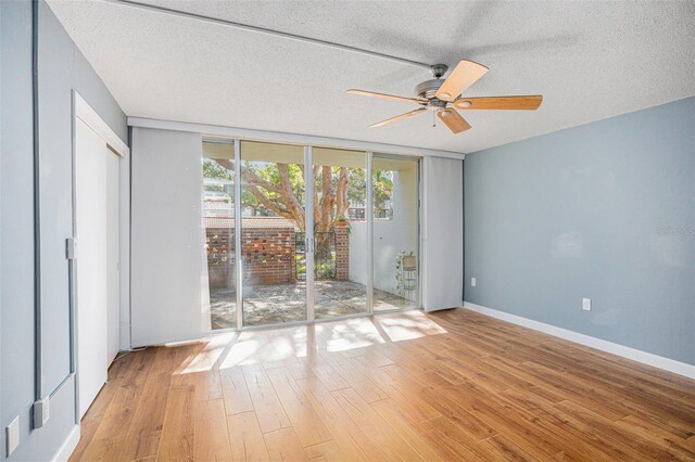 2635 Seville Blvd Unit 109, Clearwater, FL 33764 - spare room with a wall of windows, light hardwood / wood-style flooring, and a textured ceiling