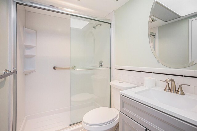 2635 Seville Blvd Unit 109, Clearwater, FL 33764 - bathroom with toilet, an enclosed shower, tile walls, vanity, and backsplash