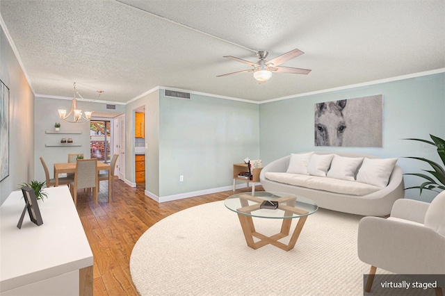 2635 Seville Blvd Unit 109, Clearwater, FL 33764 - living room featuring ceiling fan with notable chandelier, ornamental molding, hardwood / wood-style floors, and a textured ceiling