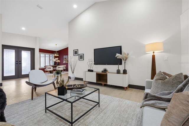 5809 Cruiser Way, Tampa, FL 33615 - living area featuring light wood-style floors, a chandelier, french doors, recessed lighting, and high vaulted ceiling