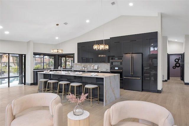 5809 Cruiser Way, Tampa, FL 33615 - kitchen featuring high quality fridge, dark cabinets, a chandelier, modern cabinets, and a kitchen bar
