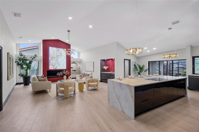 5809 Cruiser Way, Tampa, FL 33615 - kitchen with a chandelier, modern cabinets, high vaulted ceiling, light wood-style flooring, and recessed lighting