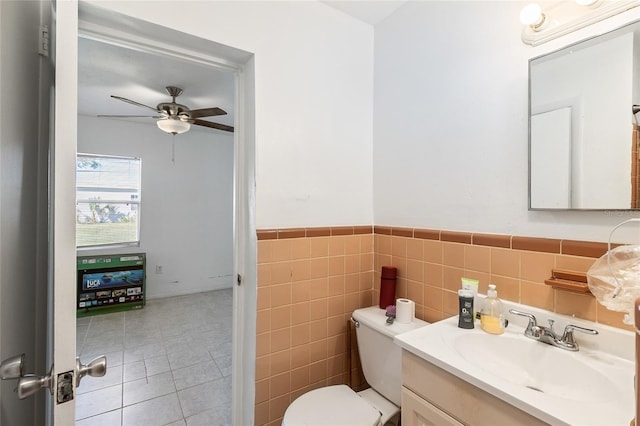 27284 Sunnybrook Rd, Punta Gorda, FL 33983 - bathroom featuring toilet, tile walls, vanity, ceiling fan, and tile patterned flooring