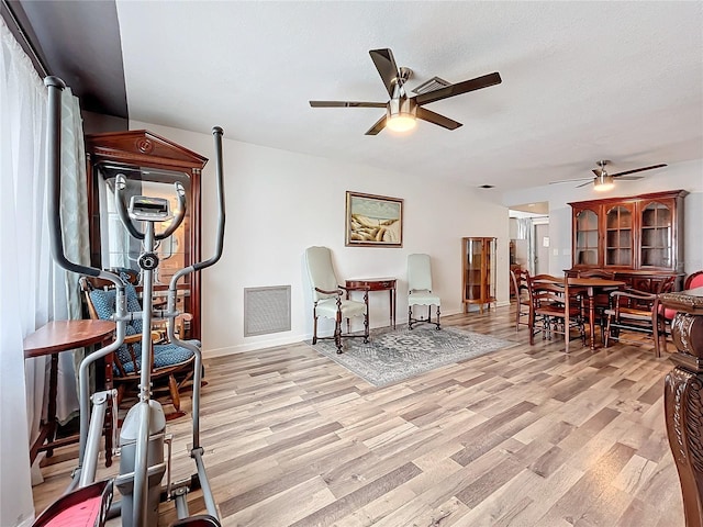 living area with ceiling fan and light hardwood / wood-style flooring