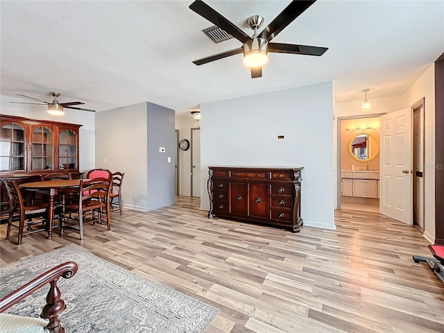 living room with ceiling fan and light wood-type flooring