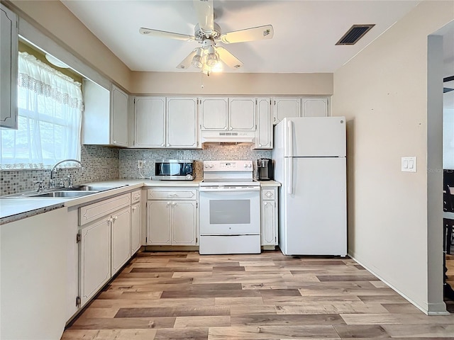 kitchen with white cabinetry, white appliances, and light hardwood / wood-style flooring