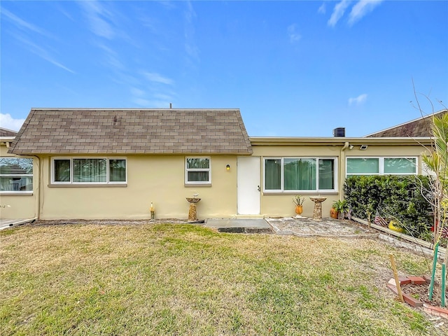 rear view of house featuring a patio and a lawn