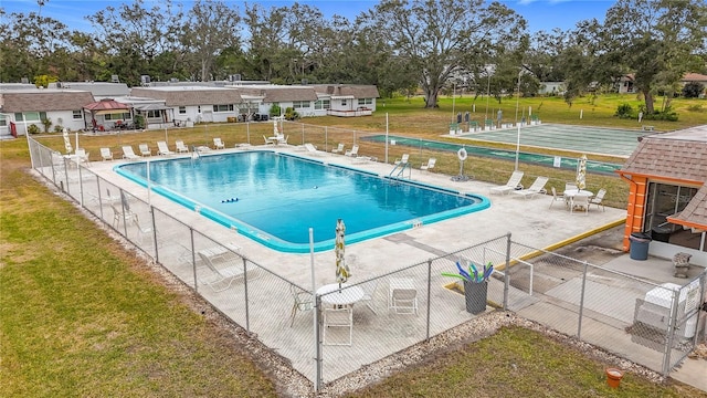 view of swimming pool featuring a patio and a lawn