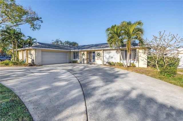 single story home featuring a garage, driveway, and stucco siding