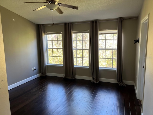 empty room featuring dark hardwood / wood-style flooring, ceiling fan, and a textured ceiling