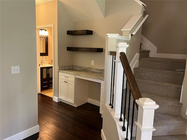 stairway with built in desk and hardwood / wood-style floors