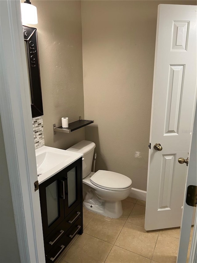 bathroom with decorative backsplash, tile patterned floors, toilet, and vanity