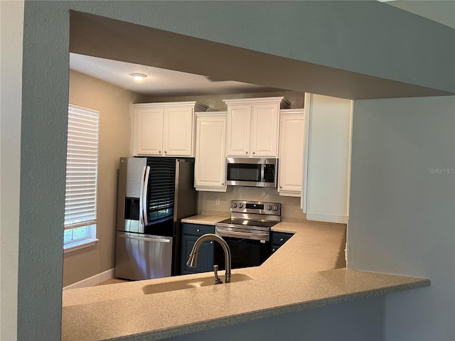 kitchen featuring stainless steel appliances, sink, and white cabinets