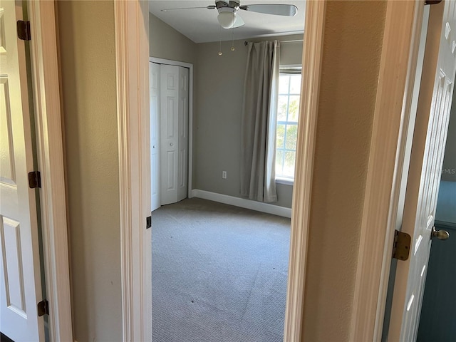 hallway with carpet and lofted ceiling