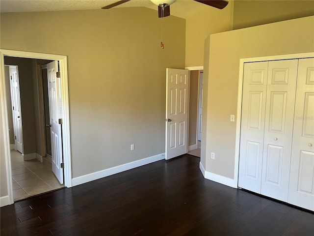 unfurnished bedroom with ceiling fan, lofted ceiling, dark hardwood / wood-style flooring, and a closet