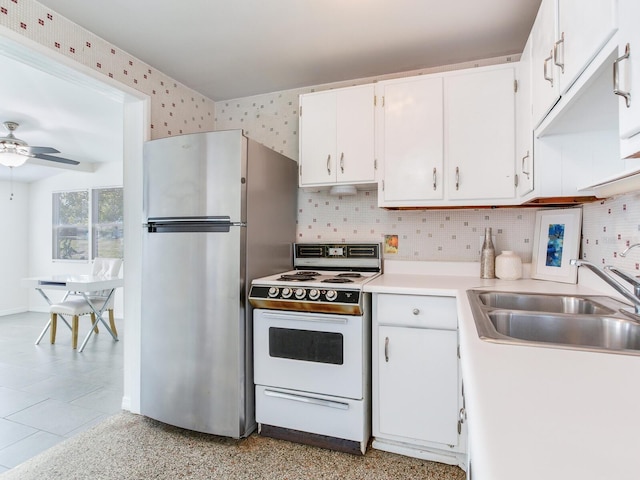 kitchen with sink, backsplash, white cabinets, white electric range, and stainless steel refrigerator