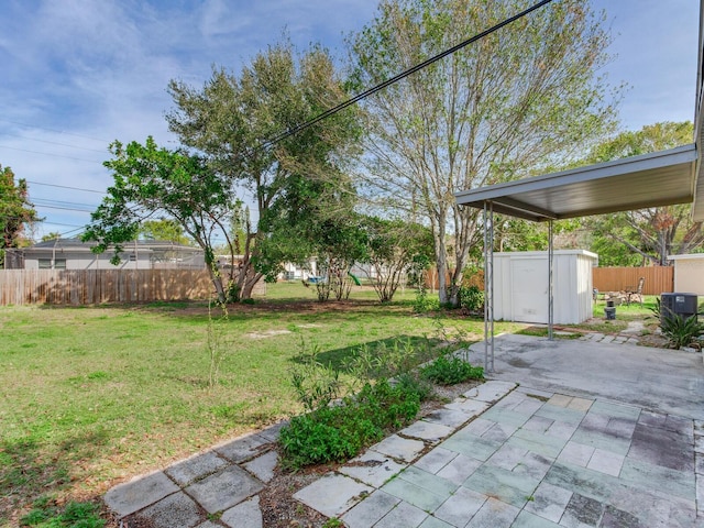 view of yard featuring central air condition unit, a patio, and a storage unit