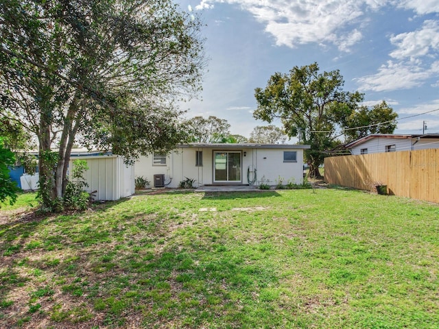 back of property featuring a yard and central AC