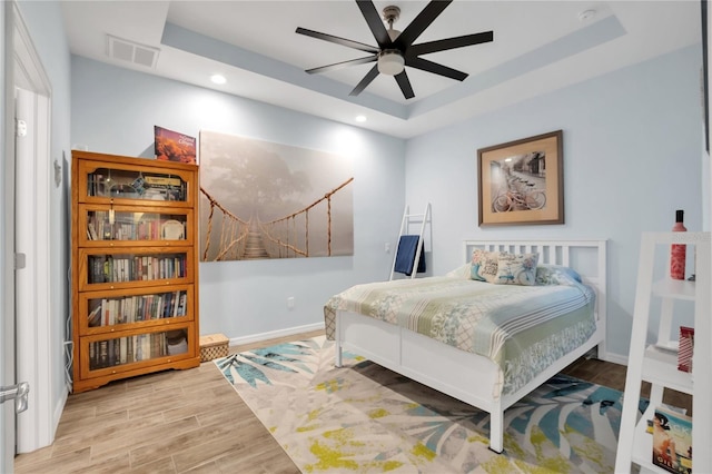 bedroom with a raised ceiling and ceiling fan