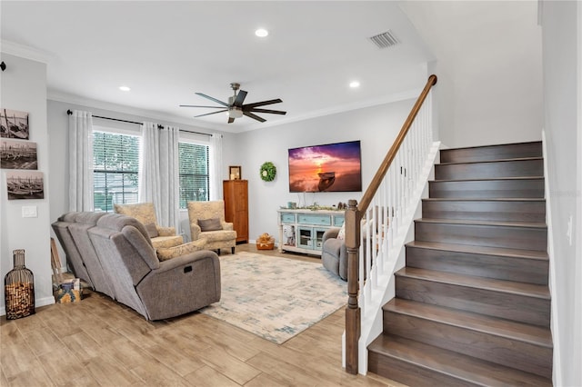 living room with crown molding and ceiling fan