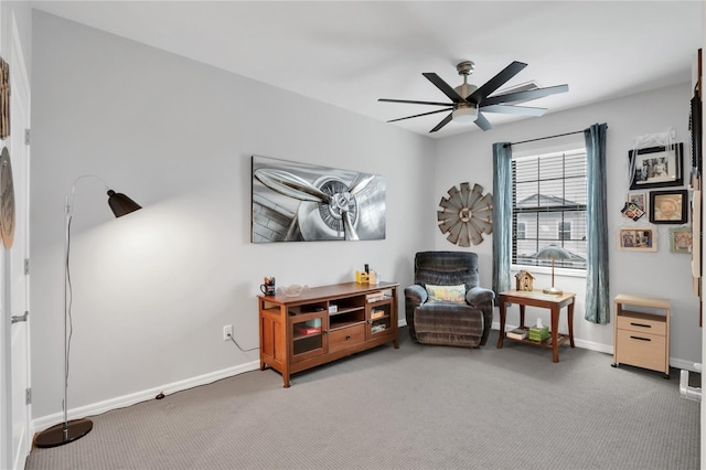 sitting room with ceiling fan and carpet