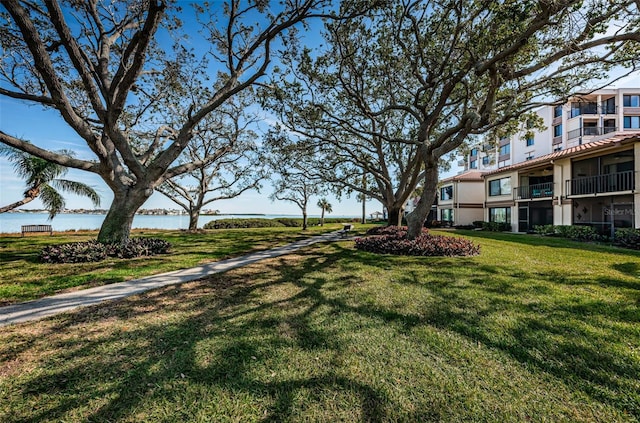 surrounding community featuring a water view and a yard