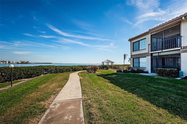 surrounding community with a gazebo, a water view, and a yard