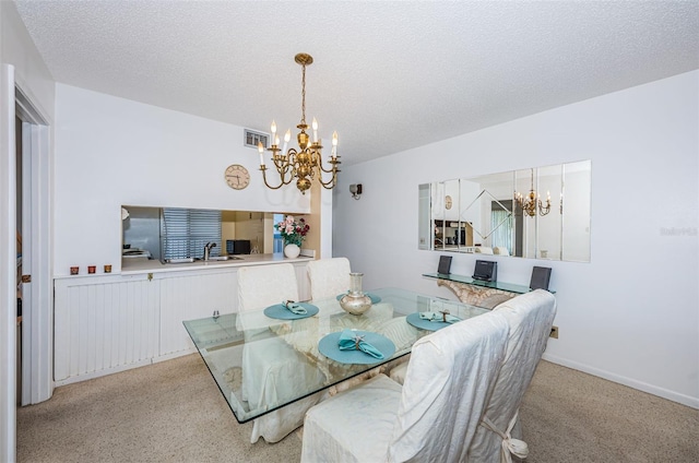 dining area featuring an inviting chandelier, sink, and a textured ceiling