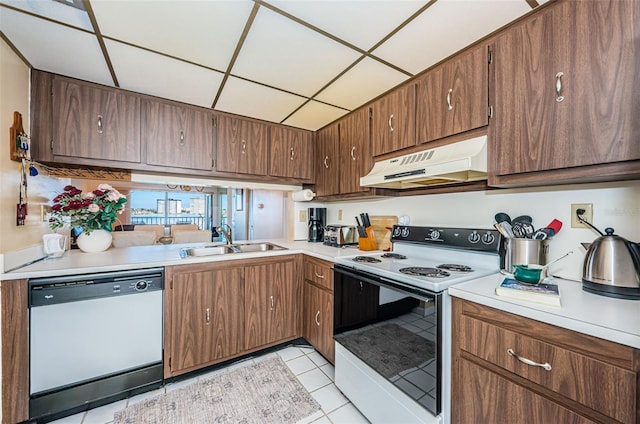 kitchen featuring electric range oven, white dishwasher, light countertops, under cabinet range hood, and a sink